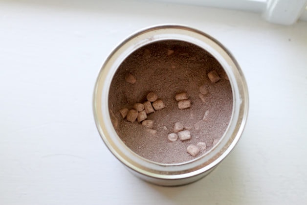 an opened tin of hot chocolate mix.